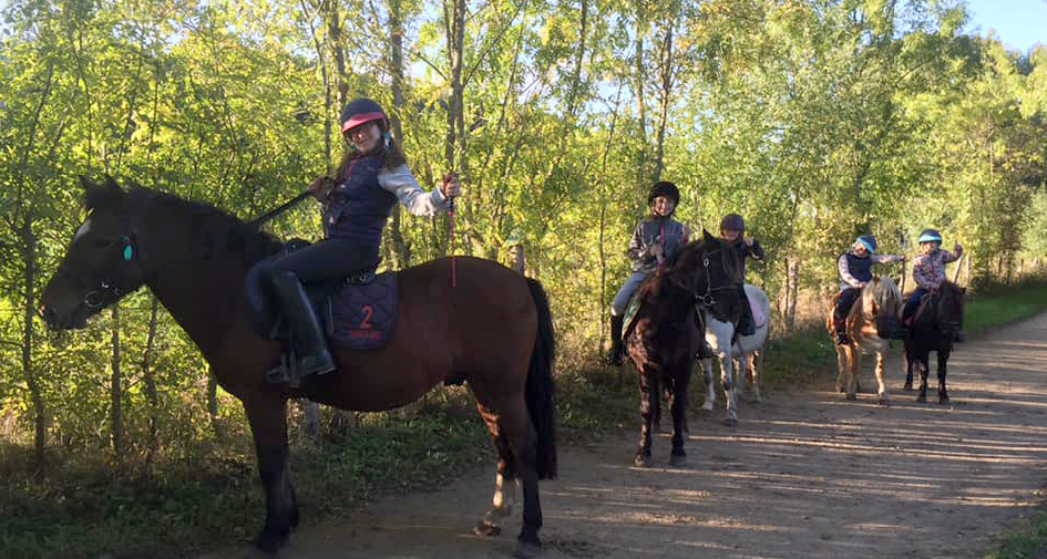 Groupe de 5 cavaliers en balade poney dans le chemin d’une forêt au Mans